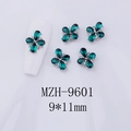 Dettaglio di gioiello per unghie a fiore verde smeraldo con strass su modello bianco - Gemma Verde Smeraldo - Base Tono Argento (MZH-9601)