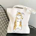 Kawaii white canvas tote bag featuring a cute hand-drawn orange cat print with paw up - Waving Ginger Cat
