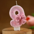 Pink number 8 birthday candle with colorful glitter and a small bow decoration - Number 9