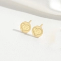 Macro di orecchini a cuore dorati con trama a croce su sfondo di seta bianca - Forma di Cuore / Oro