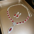 Primer plano del conjunto de joyas con cristales rojos, collar y pendientes de botón - Set de Circonita Roja