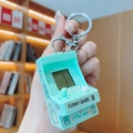 Mint green mini game console keychain with a joystick and cute dinosaur illustration - Green Mini Arcade Game Console