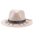 Détail d'un chapeau de paille bohème avec ruban ethnique et pendentifs en feuilles - Rose
