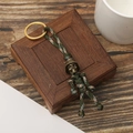 Detail of paracord keychain with helmet skull charm and camo green braided cord - Camouflage