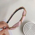 Pink twisted fabric headband with gold chain and dark rhinestone details in hand - 210447 Pink