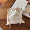 Close-up of minimalist cotton drawstring pouch with floral print on a rustic wood table - Beige Base Grey Dot Pink Floral
