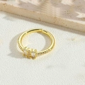 Macro shot of gold cross-set ring with sparkling crystals on textured stone base - White Zirconia Style-2
