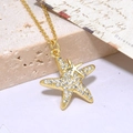 Collana dorata con doppia stella marina e zirconi scintillanti su sfondo stile retrò - Stella Marina / Oro