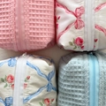 Detailed top view of four bow-tie cosmetic bags featuring waffle textures and floral patterns - 17.5*12*10cm / Waffle Blue