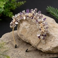 Detailopname van handgemaakte gouden haarband met paarse kristallen en parelbloemen - Amethist Gouddraad Gouden Bloem