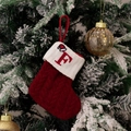 Red cable knit Christmas stocking with letter F embroidery hanging on a tree - Style F