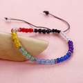 Macro detail of rainbow beaded bracelet featuring red agate and black woven cord - Multi-color Transparent Beads