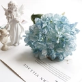 Artistic detail of a large blue and white gradient artificial hydrangea on a white desk - Dark Blue