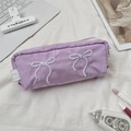 Detail view of purple pencil case with white bow embroidery and top zipper closure - Purple