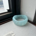 Wide irregular resin bangle in light blue marble texture with minimalist swirl design - Transparent Blue