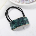 Detail of emerald marble acetate hair tie with golden metal frame and elastic band - Green