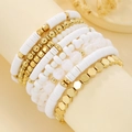 Detail of stacked boho bracelets with white heishi clay beads and golden metal accents - White Pink Gold Combo