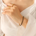Elegante gouden armband met zwarte zirkonia steentjes gedragen door een model - Zwarte Zirkoon Armband-17cm