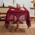 Dark red hollow geometric tablecloth with black tassel edges on a wooden dining table - Burgundy Crochet Diamond