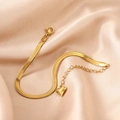 Detail of gold snake chain bracelet with lobster clasp and heart pendant on silk - Bracelet / Gold