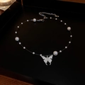 Detailed shot of silver butterfly charm and white pearls on an adjustable necklace - Style 10 Necklace / Silver
