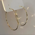 Close-up of elegant gold hoop earrings with hammered texture on white display card - Hammered Texture Style / 59mm / Gold