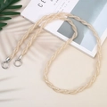 Detailed view of champagne gold woven crossbody phone strap with silver spring buckles - Champagne
