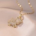 Macro-opname van een gouden eenhoorn hanger met witte zirkonen op roze zijden stof - Gouden Eenhoorn Ketting / Klein