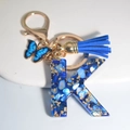 Royal blue resin letter K keychain with gold foil, tassel, and butterfly charm - Letter K