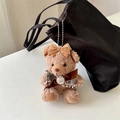 Close-up of brown plush bear charm with velvet bows and pearl detail on a black bag - Brown Bow Pearl Brown Bear Bag Charm