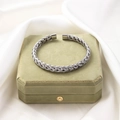 Close-up of woven titanium steel cuff bracelet texture on a velvet jewelry box - Steel 3