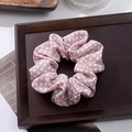 Pink scrunchie with white polka dots in a wooden tray for vintage hair styling - Pink