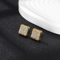 Makroaufnahme von quadratischen Goldsteckern mit glitzernden Steinen im Hip-Hop-Stil - Goldene 3D-quadratische Ohrstecker