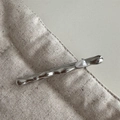 Dettaglio di un fermaglio per capelli in metallo ondulato argento con perla bianca su lino - Stile Corto-Argento / Perla grande singola