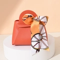 Mini orange leather wedding favor bag with horse-print scarf handle on white stand - Orange