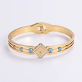 Vista de detalle de pulsera dorada con ojo de la suerte, cuentas azules y diamantes - Dorado