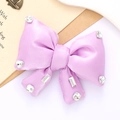 Macro shot of light purple satin bow accessory with sparkling rhinestone details - Purple