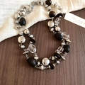 Close-up of vintage beaded necklace with dark wood beads and silver metal details - Necklace-Silver-Coffee