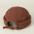 Detail of dark brown cotton docker hat featuring back bow tie and textured fabric finish - Rust red