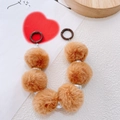 Dettaglio del ciondolo per borsa con pompon marroni e perline in argento - caffè