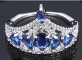 Elegant silver crown ring featuring deep blue sapphire zirconia and white micro-pave stones - Ur0593b / Size 6