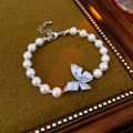 Dettaglio del bracciale di perle con farfalla di cristallo blu su tessuto verde oliva - Argento Bianco Blu