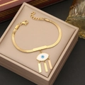 Goldenes Evil Eye Armband mit Lucky Gravur und Quasten in einer Schmuckschatulle - Armband