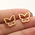 Detailed view of a gold hollow butterfly stud earring held on a finger for size reference - 670 Hollow Winged Butterfly / Gold