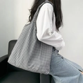 Detailed close-up of a large black and white gingham tote bag worn over the shoulder - Black Plaid