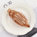 Translucent brown oval claw clip with hollow design on a white decorative plate - 11.5cm / Jelly Coffee