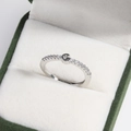 Macro shot of silver letter G ring with clear crystals on green velvet jewelry box - Platinum G