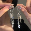 Detailed macro view of long silver tassel earrings with tiered metal leaf pendants - Leaf Long Tassel / Silver