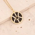 Macro detail of gold star pendant with micro-paved zircons on black inlay disk - Black