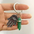 Detail von Hamsa-Hand und grünem sechseckigem Kristall an einem Metall-Schlüsselanhänger - Grüner Aventurin